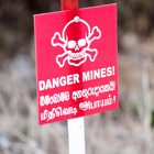 A mine warning sign stands outside